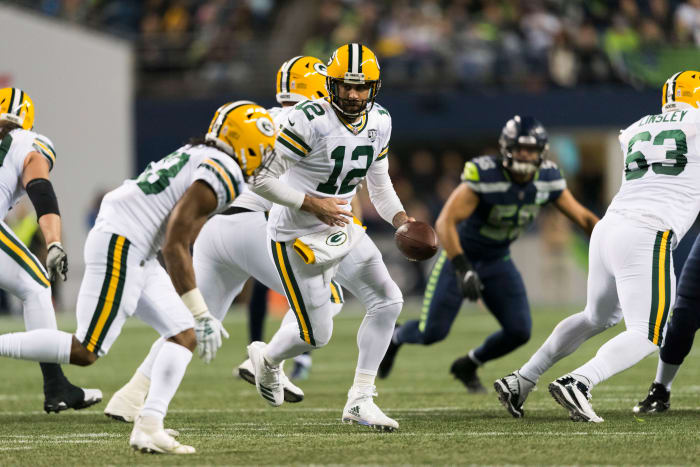 Green Bay Packers quarterback Aaron Rodgers hands the ball off to running back Aaron Jones.